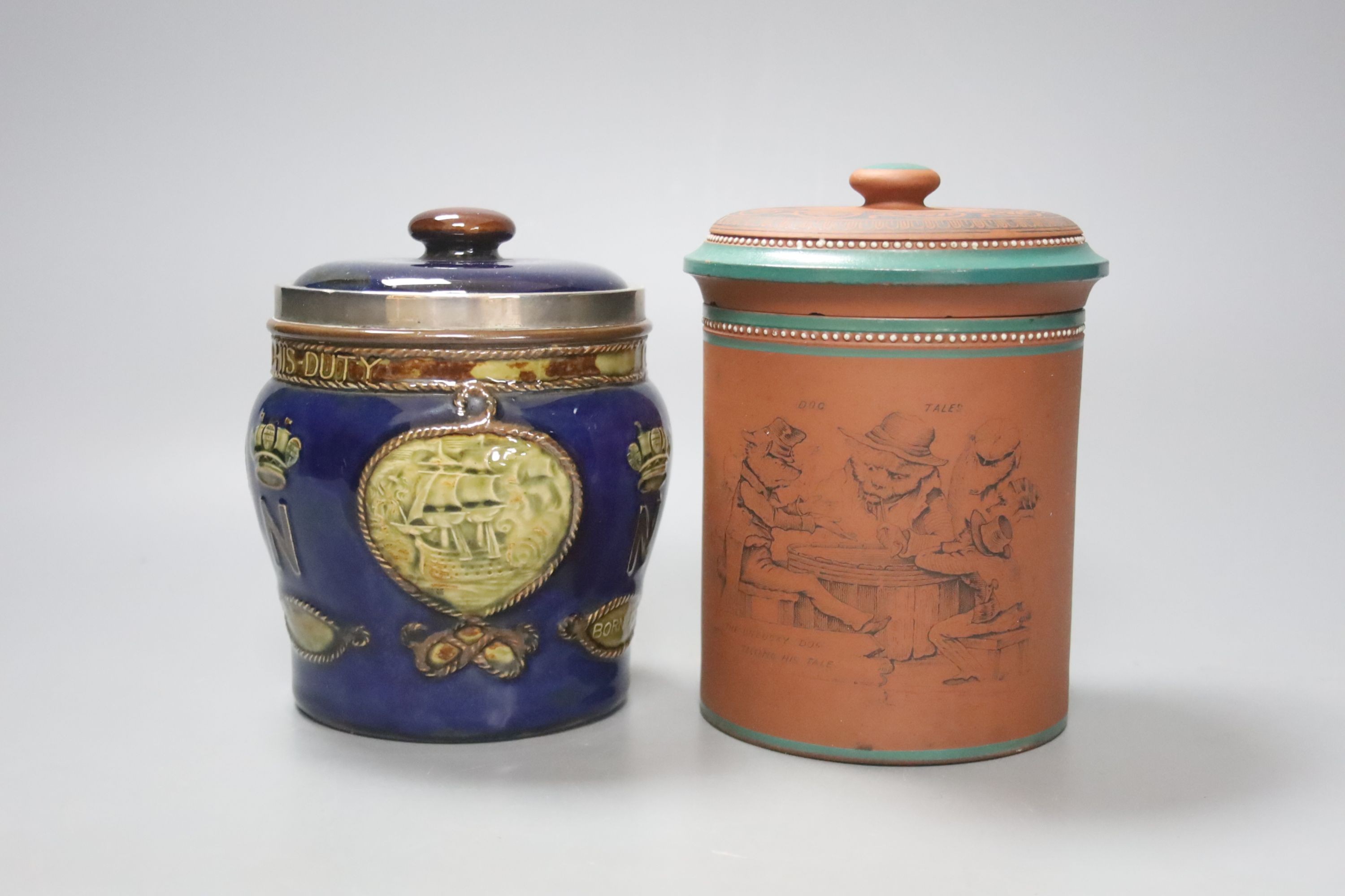 A Doulton Lambeth Nelson commemorative tobacco jar and cover 13.5 cm high, with silver mount (cracked) and a Watcombe style terracotta tobacco jar and cover (2)